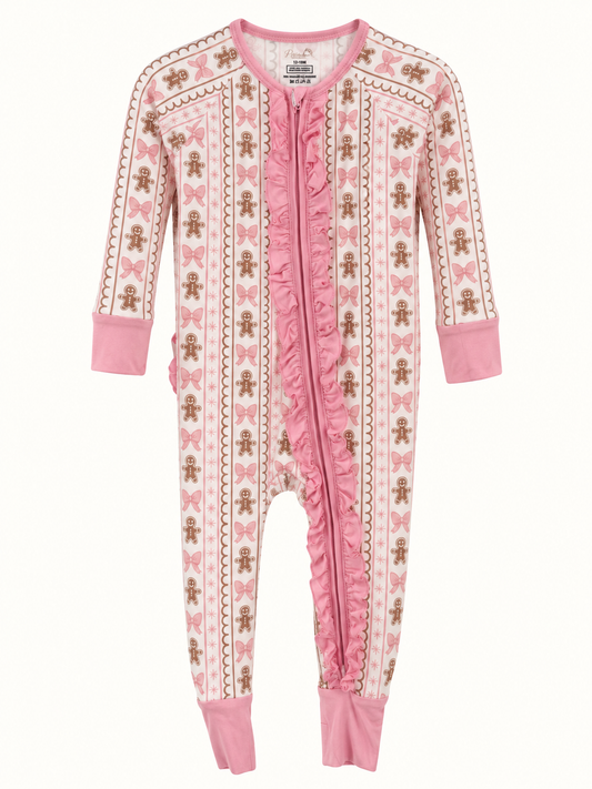 A baby's long-sleeve footless zip-up sleeper in pink and cream, decorated with a pattern of gingerbread men and bows, shown against a plain white background.